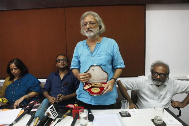 Filmmaker Anand Patwardhan showing his national award which he is returning in protest against the growing intolerance around the nation and the unsolved FTII issue as Nistha Jain (L) and Dibakar Banerjee (2nd L) and Paresh Kamdar (R) looks on during a press conference at Mumbai Press Club on October 28, 2015. (Hindustan Times) Filmmaker Anand Patwardhan showing his national award which he is returning in protest against the growing intolerance around the nation and the unsolved FTII issue as Nistha Jain (L) and Dibakar Banerjee (2nd L) and Paresh Kamdar (R) looks on during a press conference at Mumbai Press Club on October 28, 2015. (Hindustan Times)