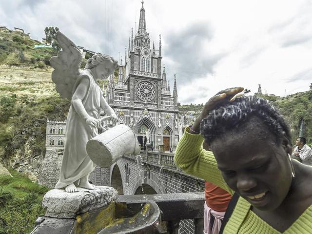 The basilica is located at Ipiales, 1070 km south of Bogota, on the border with Ecuador. A pilgrim wets her hair with holy water at the sanctuary. (AFP)