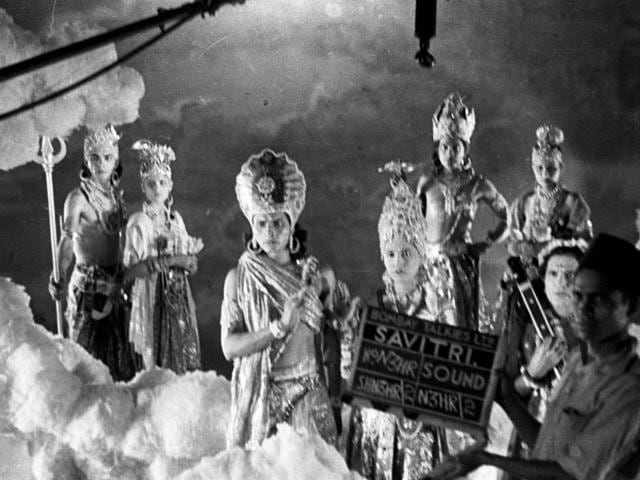 A still from the making of Savitri, 1937. The studio was made up to look like heaven, with numerous Indian Gods looking down at the mortal human race. The clapper boy and the overhanging boom microphone adds a nice touch to the image. (Josef Wirsching)