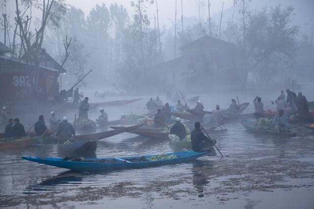 Kashmiris sell their produce at the floating vegetable market on the Dal Lake surrounded by dense fog on a cold morning in Srinagar. (AP) Kashmiris sell their produce at the floating vegetable market on the Dal Lake surrounded by dense fog on a cold morning in Srinagar. (AP)