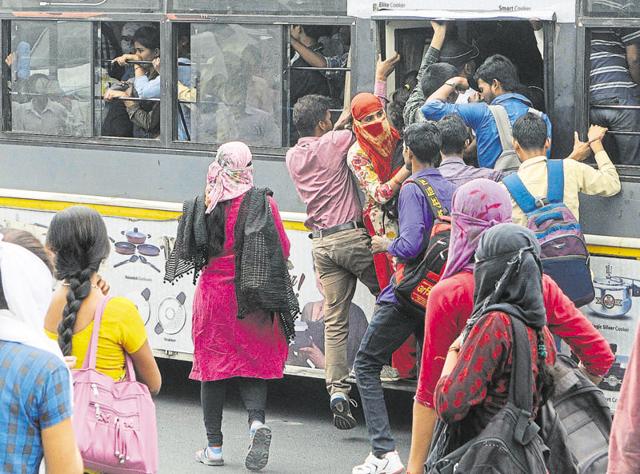 Students and other commuters compete to board a moving low-floor bus due to the strike by mini bus operators, on Tonk Road in Jaipur on Wednesday. (Himanshu Vyas/HT photo)