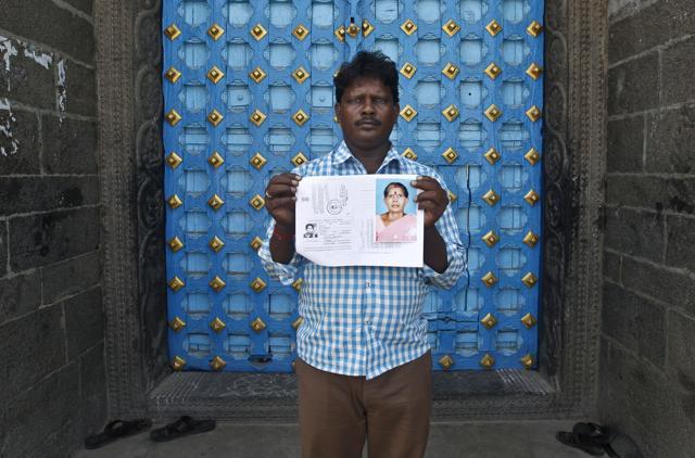Mohan Munirathinam, son of Kasthuri Munirathinam, displays his mother’s photograph and a copy her employment documents in Chennai. (AP) Mohan Munirathinam, son of Kasthuri Munirathinam, displays his mother’s photograph and a copy her employment documents in Chennai. (AP)