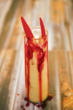 Garnish with the pineapple wedge and raspberry syrup.