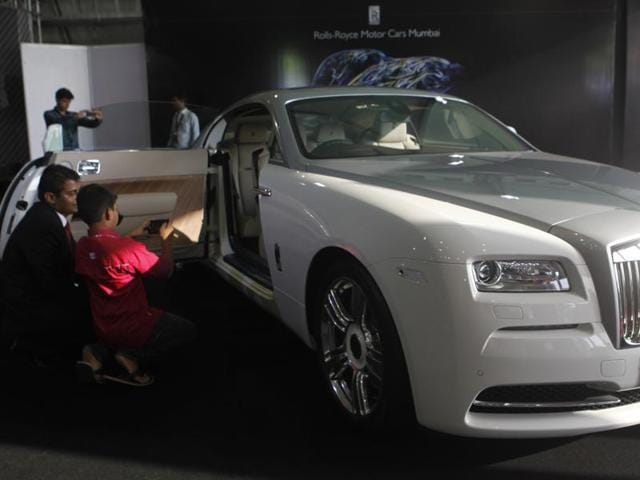 A boy takes a picture of the luxurious Rolls Royce Wraith. (Satish Bate/HT)