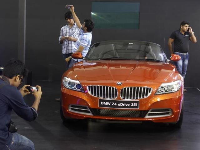 Dream car clicks: A man poses with a BMW at the expo. (satish Bate/HT)