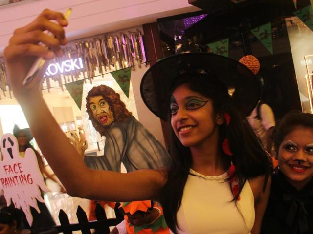 Children take a selfie after getting their faces painted during the Halloween party in Lower Parel, Mumbai, on Friday. (Pramod Thakur/HT photo)
