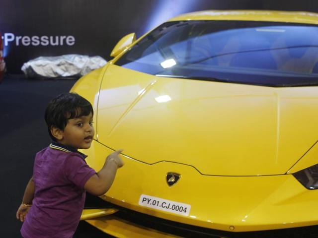 A child poses next to a Lamborghini on display at Mumbai’s Bandra Kurla Complex. The tenth edition of the Autocar Performance Show kicked off in Mumbai, featuring a stunning line-up for auto mobile enthusiasts. (Satish Bate/HT)