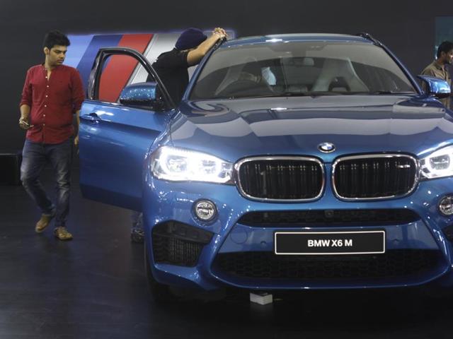 Visitors to the expo explore a BMW X6 M. (Satish Bate/HT)