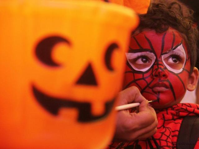 A child gets a Spiderman mask painted on his face at the Halloween bash at a mall in Lower Parel, Mumbai, on Friday. Halloween is celebrated in many countries on October 31, the eve of All Saints Day. Festivities on this day include carving pumpkins, dressing up in scary costumes, watching horror films and playing pranks. (Pramod Thakur/HT photo)