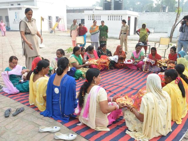 Seeking the blessings of God for their husband’s long life, a group of women perform rituals after meeting their husbands who are prisoners in Central Jail Amritsar on the occasion of ‘Karva Chauth' in Amritsar. (Sameer Sehgal/ HT photo)