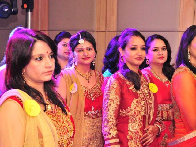 Karvachauth traditionally observed to pray for the long life of the husband, is not so much about fasting but lots of celebrations as the ladies adorned in bridal colours can be seen participating in a fashion show during the celebrations of Karva Chauth at Prithvi Planet in Jalandhar on Friday. (Pardeep Pandit/ HT photo)
