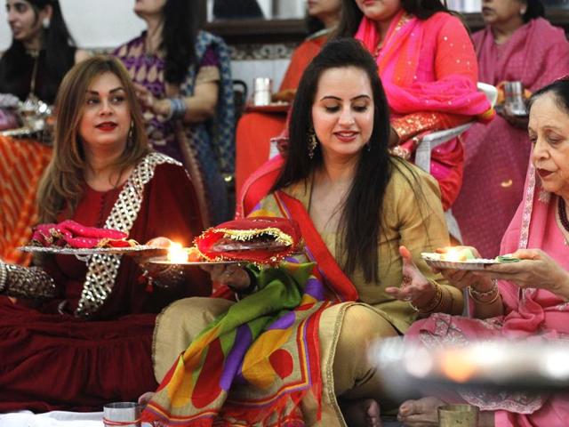 Women wear traditional attires and apply henna on their hands to mark the annual Karva Chauth puja, at Defence Colony in New Delhi. (Sanchit Khanna/HT Photo)