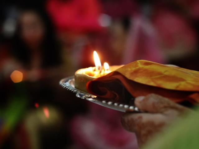 A woman holds a platter of traditional elements required for the Karva Chauth puja, in New Delhi. (Sanchit Khanna/HT Photo)