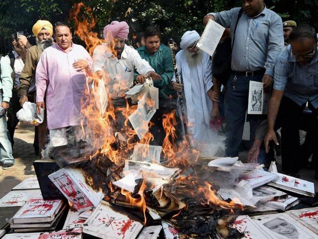 Sikh protesters on Friday burnt books questioning the authors’ silence on 1984 anti-Sikh riots issue in New Delhi. (PTI) Sikh protesters on Friday burnt books questioning the authors’ silence on 1984 anti-Sikh riots issue in New Delhi. (PTI)