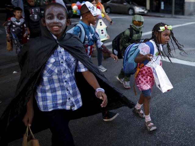 Children go trick-or-treating to local stores as they participate in the School on Wheels Skid Row Halloween Parade for children who live in shelters, motels, cars and on the street, in Los Angeles, California. (REUTERS)