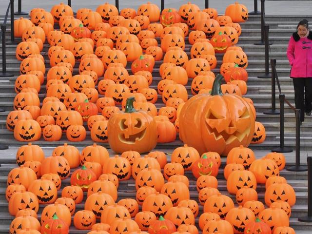 A woman walks down a stairway partially filled with decorations in the shape of carved pumpkins to celebrate Halloween in Shenyang, Liaoning province, China. (REUTERS)