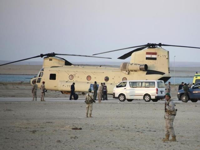 Egyptian soldiers stand guard as rescuers carry bodies of victims of a plane crash from a civil police helicopter to ambulances at Kabrit airport in Suez, 100 kilometers east of Cairo, Egypt. (AP Photo)