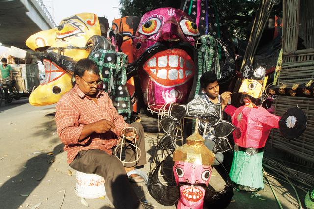 Michael Ekka and his son Amit work on bamboos, which are used to form the frame on which the putlas are erected. (Photo by Virendra Singh Gosain/ Hindustan Times) (Hindustan Times)