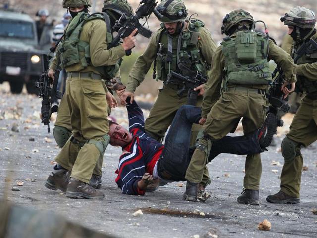 Palestinian protesters try to pick up a tear gas canister to throw it away from demonstrators during clashes with Israeli soldiers. (AP Photo) Palestinian protesters try to pick up a tear gas canister to throw it away from demonstrators during clashes with Israeli soldiers. (AP Photo)