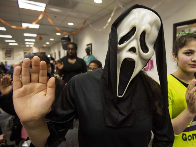 Javaria Khattak (L), 14, and her sister Mishal Khattak, 12, both from Pakistan take the US oath of allegiance along with 26 other children from 19 countries during a special Halloween-themed ceremony at the US Citizenship and Immigration Services (USCIS) Washington Field Office in Fairfax, Virginia. (AFP)