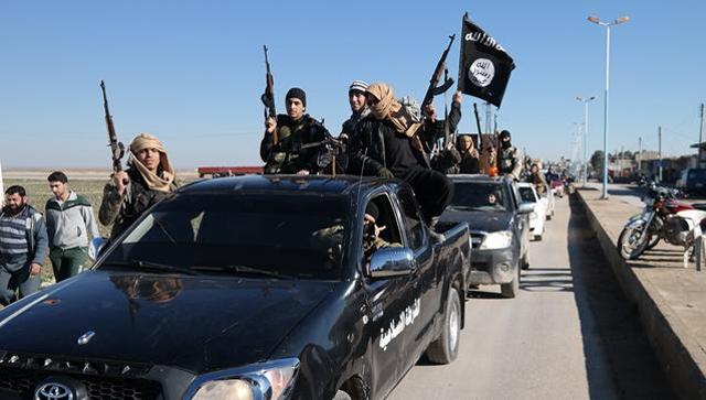 Islamic State militants pass by a convoy in Tel Abyad, northeast Syria. (AP File Photo) Islamic State militants pass by a convoy in Tel Abyad, northeast Syria. (AP File Photo)