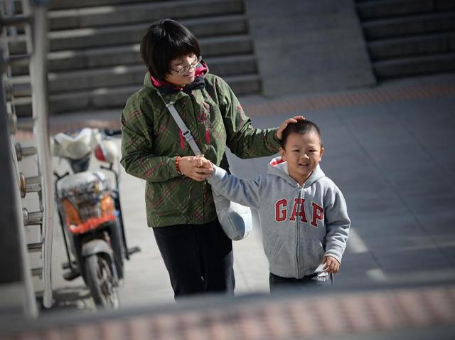 A woman takes a child's hand as they walk through an underpass in Beijing. (AFP) A woman takes a child's hand as they walk through an underpass in Beijing. (AFP)