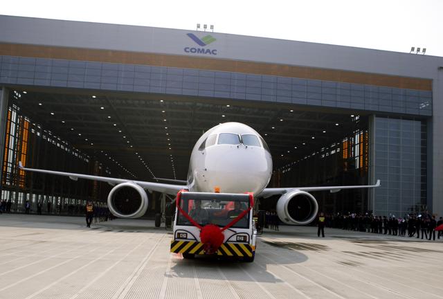 Chinese workers wave flags as a truck pulls out the twin-engine 158-seater C919 passenger plane made by The Commercial Aircraft Corp. of China (COMAC) during a ceremony at the company's hangar near the Pudong International Airport in Shanghai. (AP) Chinese workers wave flags as a truck pulls out the twin-engine 158-seater C919 passenger plane made by The Commercial Aircraft Corp. of China (COMAC) during a ceremony at the company's hangar near the Pudong International Airport in Shanghai. (AP)