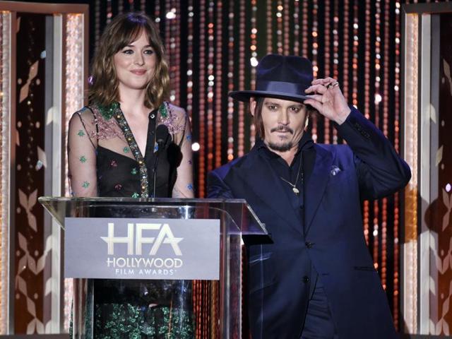 Dakota Johnson, left, and Johnny Depp present the Hollywood breakout actor award at the Hollywood Film Awards at the Beverly Hilton Hotel. (AP)