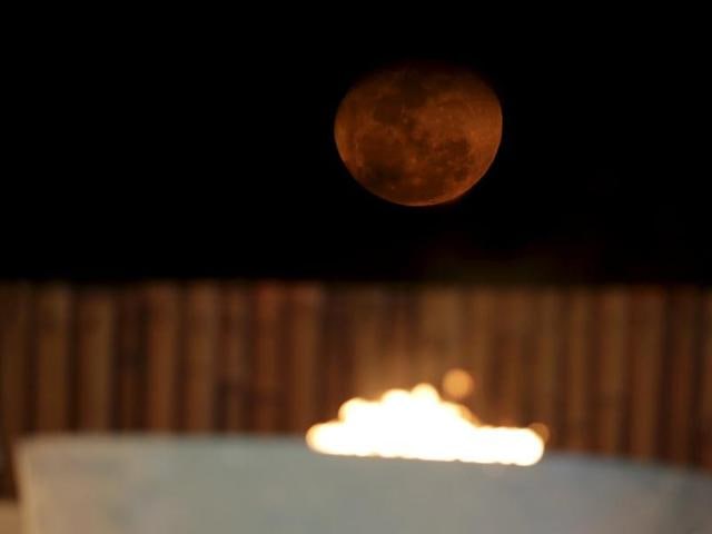 The moon is seen over the flame of the first World Games for Indigenous Peoples in Palmas, Brazil (REUTERS) The moon is seen over the flame of the first World Games for Indigenous Peoples in Palmas, Brazil (REUTERS)