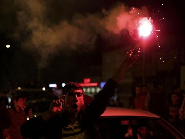 A man burns a flare outside the headquarters of Turkey's pro-Kurdish HDP opposition party in Diyarbakir, Turkey . (REUTERS)