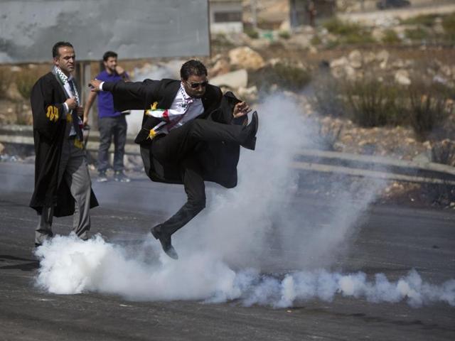 A lawyer wearing his official robes kicks a tear gas canister back toward Israeli soldiers during a demonstration by scores of Palestinian lawyers called for by the Palestinian Bar Association in solidarity with protesters at the Al-Aqsa mosque compound in Jerusalem's Old City, near Ramallah, West Bank. (AP) A lawyer wearing his official robes kicks a tear gas canister back toward Israeli soldiers during a demonstration by scores of Palestinian lawyers called for by the Palestinian Bar Association in solidarity with protesters at the Al-Aqsa mosque compound in Jerusalem's Old City, near Ramallah, West Bank. (AP)