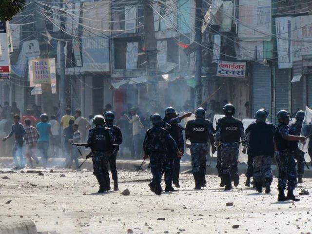 Nepalese police watch protesters throwing rocks during clashes near the Nepal-India border at Birgunj, some 90 km south of Kathmandu. (AFP Photo)