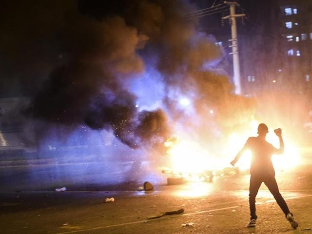 A young man prepares to throw a stone as pallets burn during clashes between Turkish riot policemen and Kurdish protesters in the southeastern city of Diyarbakir after first results of the Turkish general election showed a clear victory to the Justice and Development Party (AKP). (AFP)