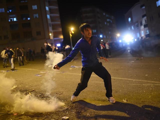 A man prepares to throw back a tear gas fired by Turkish riot police during clashes Kurdish protesters in the southeastern city of Diyarbakir. (AFP)