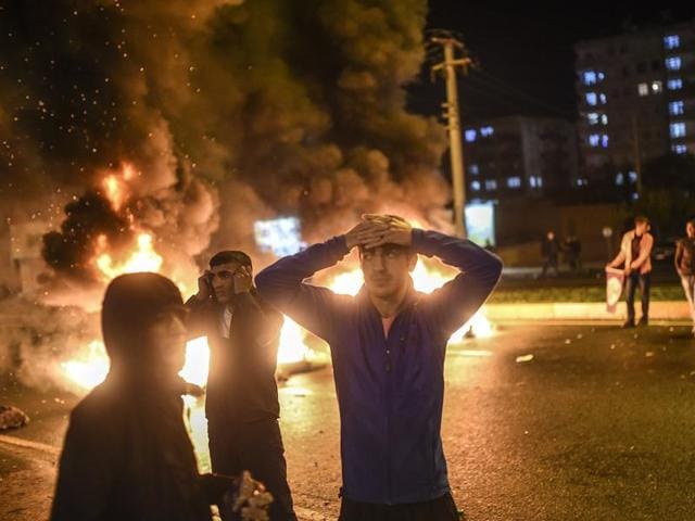 People react as smoke billows from burning pallets set on fire during clashes between Turkish riot policemen and Kurdish protesters in the southeastern city of Diyarbakir on November 1, 2015 . (AFP)
