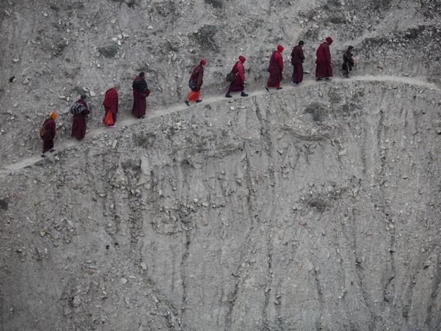 Monks and nuns walk across a steep hill back to their dormitory after attending a daily chanting session during the Utmost Bliss Dharma Assembly. Picture taken November 1, 2015. (REUTERS)