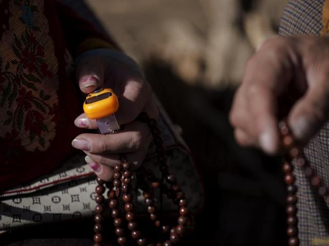 Khenpo Jigme Phuntsok, an influential lama of Nyingma sect of Tibetan Buddhism, founded Larung Wuming Buddhist Institute with only around 30 students. Ethnic Tibetan Buddhist believers hold electronic mantra counter (L) and prayer beads on the hill near the Larung Wuming Buddhist Institute. Picture taken October 31, 2015. (REUTERS)