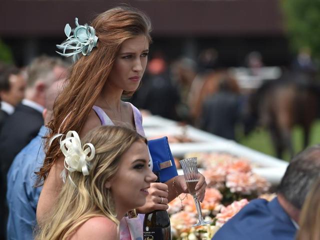 Racegoers watch horses in the parade ring. (AFP)