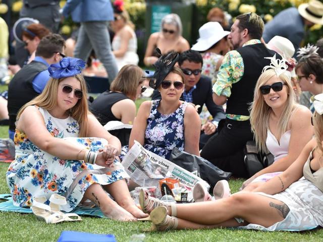 Racegoers relax with a picnic on the lawns. (AFP)