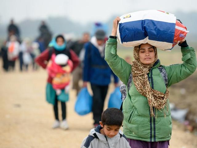 A woman carries her belongings as migrants and refugees walk towards buses to be taken to a refugee centers after crossing Croatian-Slovenian border in Rigonce. More than 700,000 refugees and migrants have reached Europe's Mediterranean shores so far this year, amid the continent's worst migration crisis since World War II, according to the UN refugee agency. (AFP Photo) A woman carries her belongings as migrants and refugees walk towards buses to be taken to a refugee centers after crossing Croatian-Slovenian border in Rigonce. More than 700,000 refugees and migrants have reached Europe's Mediterranean shores so far this year, amid the continent's worst migration crisis since World War II, according to the UN refugee agency. (AFP Photo)