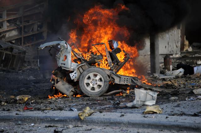 A burning car is seen on November 1, 2015 near the damaged Sahafi hotel in Mogadishu after an explosion. (AFP Photo)