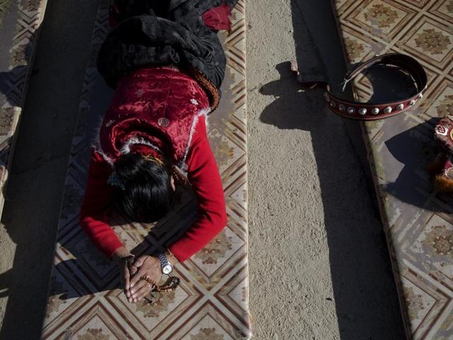 This is the great day of Buddha’s Descent from Tushita Heavens. A Tibetan woman prostrates herself at a monastery. (REUTERS)