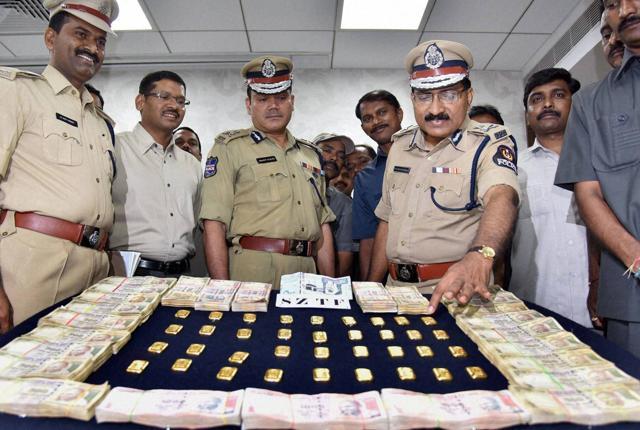 Police officials in Hyderabad look at gold biscuits and currency they seized from smugglers. India’s obsession with gold is rivalled only by China. (PTI) Police officials in Hyderabad look at gold biscuits and currency they seized from smugglers. India’s obsession with gold is rivalled only by China. (PTI)