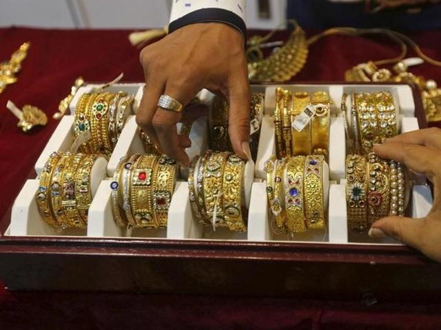 A saleswoman places a gold necklace on a shelf at a showroom in Mumbai.(REUTERS)