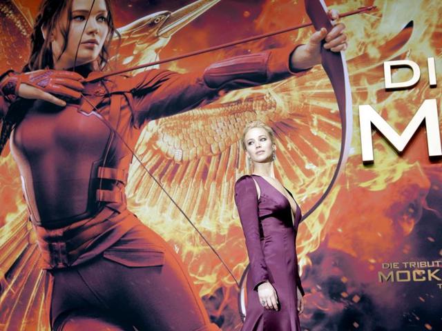 Star Jennifer Lawrence looks stunning with her poster as a backdrop at the world premiere of the final Hunger Games film in Berlin. (AP)