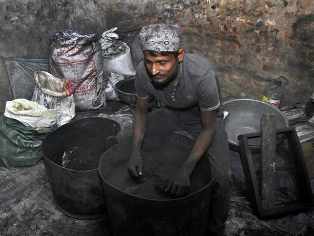 A worker sits covered in gunpowder at a firecracker factory in Farrukhnagar. (Sakib Ali)