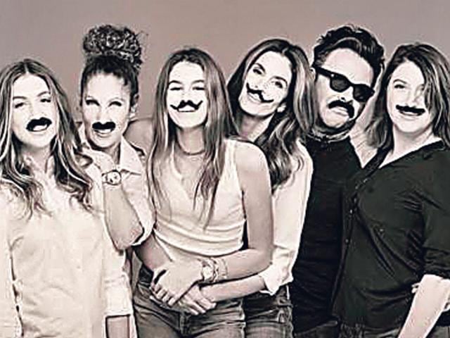 Supermodel Cindy Crawford (third from right) shared a picture of family and friends with scribbled-on mooch for Movember.