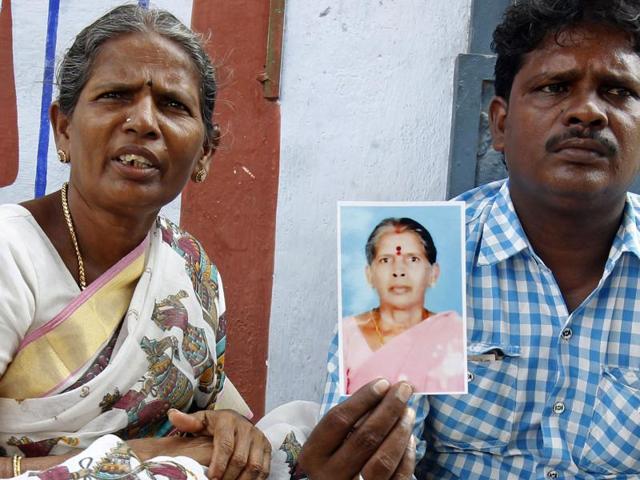 Malliga, sister, and Mohan, son, of Kasturi Munirathinam, display the maid’s photograph. (AP) Malliga, sister, and Mohan, son, of Kasturi Munirathinam, display the maid’s photograph. (AP)