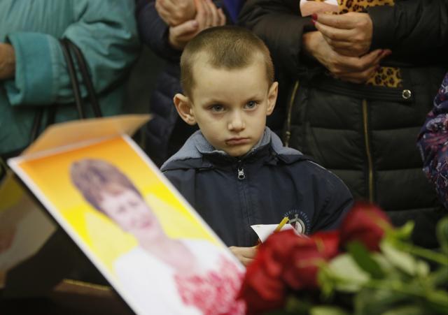 A boy stands near to the coffin of a victim of the plane crash during a religious service at a church, in Veliky Novgorod, Russia. (AP)