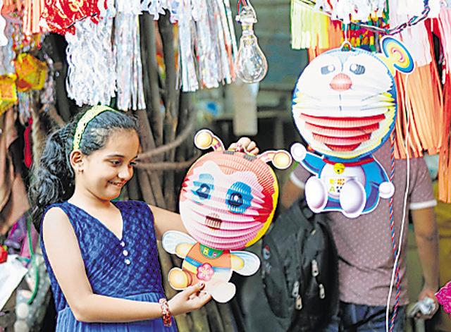 A girl looks at a cartoon-shaped lantern at the Borivli market. (Vidya Subramanian/HT Photo)